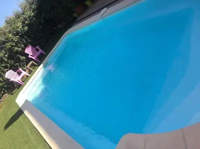 a swimming pool with two chairs and blue water at Villa Fautea Romance in Fautea