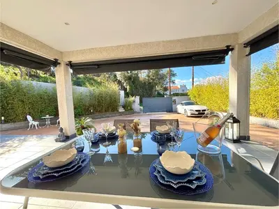 a glass table with blue plates on top of it at Villa Le Rotolo PORTICCIO in Porticcio