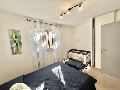 a bedroom with a bed and a window at Villa Le Rotolo PORTICCIO in Porticcio