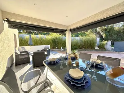 a dining room with a table and chairs and a patio at Villa Le Rotolo PORTICCIO in Porticcio