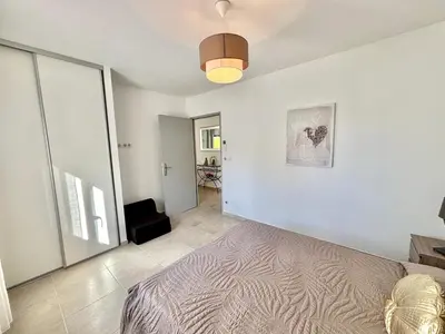a white room with a bed and a hallway at Villa Le Rotolo PORTICCIO in Porticcio