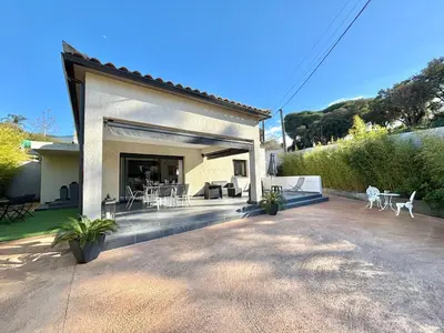 a house with a patio with chairs and tables at Villa Le Rotolo PORTICCIO in Porticcio
