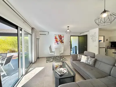 a living room with a couch and a table at Villa Le Rotolo PORTICCIO in Porticcio