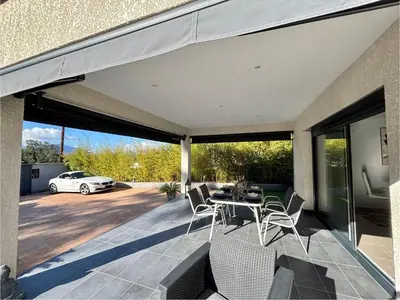 a patio with a table and chairs and a car at Villa Le Rotolo PORTICCIO in Porticcio