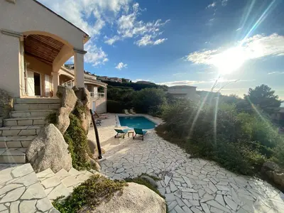 a house with a stone walkway and a swimming pool at VILLA 5 pièces 8 couchages PORTICCIO in Porticcio