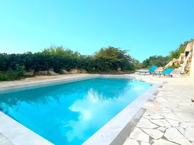a swimming pool with two blue chairs next to it at VILLA 5 pièces 8 couchages PORTICCIO in Porticcio