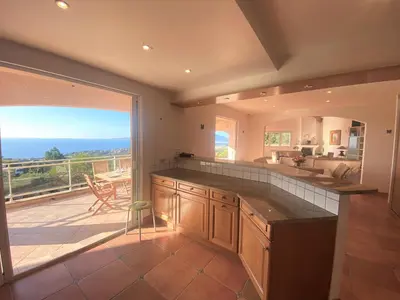 a large kitchen with a view of a patio at VILLA 5 pièces 8 couchages PORTICCIO in Porticcio