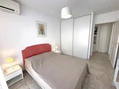 a bedroom with a bed with a red headboard at Appartement Le Diana Sanguinaires Ajaccio in Ajaccio