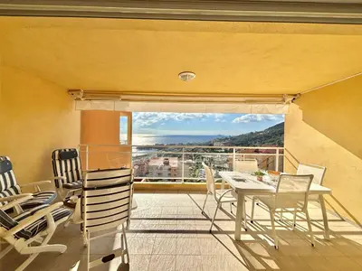 a dining room with a table and chairs on a balcony at Appartement Le Diana Sanguinaires Ajaccio in Ajaccio