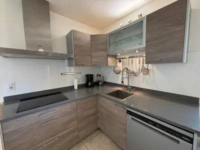 a kitchen with wooden cabinets and a sink at Appartement Le Diana Sanguinaires Ajaccio in Ajaccio