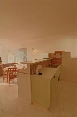 a kitchen with a counter and a table in a room at Appartement Les Couchants PORTICCIO in Porticcio
