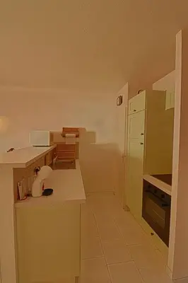 a small kitchen with a counter and a refrigerator at Appartement Les Couchants PORTICCIO in Porticcio