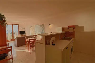a kitchen and living room with a table and a dining room at Appartement Les Couchants PORTICCIO in Porticcio