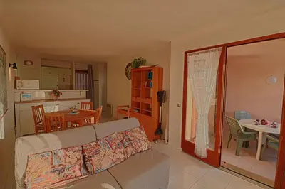 a living room with a couch and a dining room at Appartement Les Couchants PORTICCIO in Porticcio