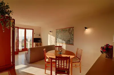 a kitchen and dining room with a table and chairs at Appartement Les Couchants PORTICCIO in Porticcio
