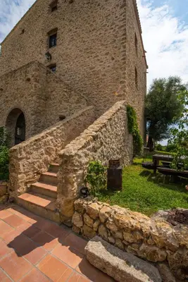 a large stone building with stairs and a stone wall at casa teppe rosse in Aléria