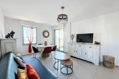 a living room with a blue couch and a table at Pretty cocoon with harbour view in Porto-Vecchio