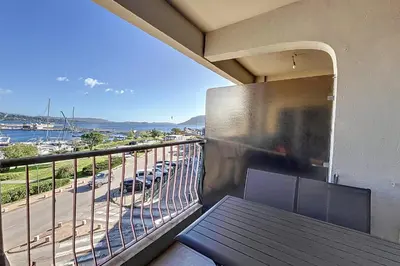 a balcony with a table and a view of a parking lot at Pretty cocoon with harbour view in Porto-Vecchio