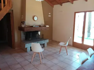 a living room with a fireplace and white chairs at Casa Jeromine in Quenza