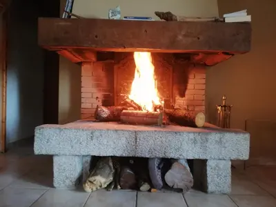 a brick fireplace with a fire in it at Casa Jeromine in Quenza