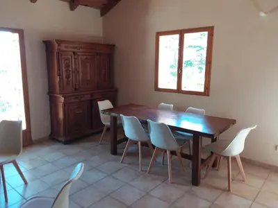 a dining room with a wooden table and chairs at Casa Jeromine in Quenza