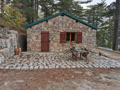 a stone building with a bench in front of it at Casa Jeromine in Quenza