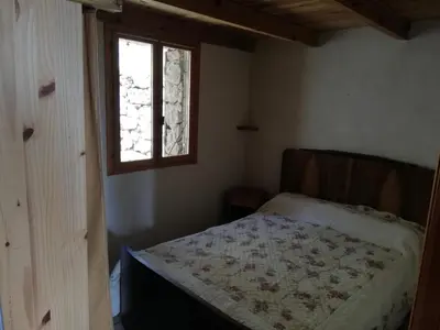 a small bedroom with a bed and a window at Casa Jeromine in Quenza