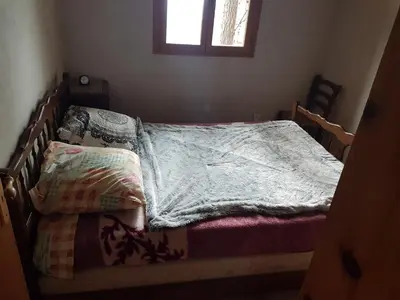 an unmade bed in a bedroom with a window at Casa Jeromine in Quenza
