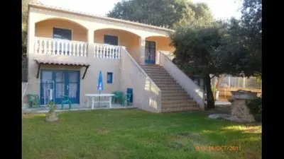 a large house with a staircase in the yard at U FILANCIU in Olmeto