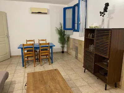 a living room with a blue table and chairs at U FILANCIU in Olmeto