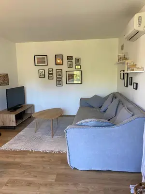 a living room with a blue couch and a table at Villa Oliera in Saint-Florent