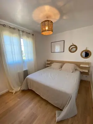 a bedroom with a white bed and a chandelier at Villa Oliera in Saint-Florent