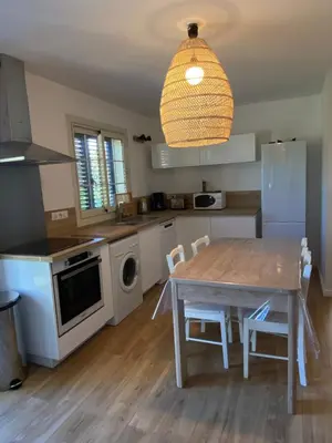 a kitchen with a wooden table and a dining room at Villa Oliera in Saint-Florent
