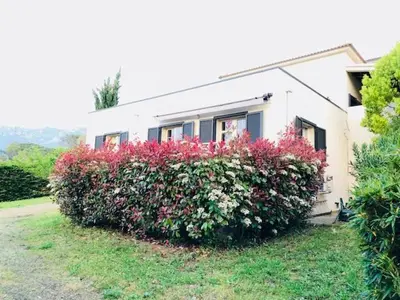 a house with a large bush of flowers in front of it at Villa Oliera in Saint-Florent