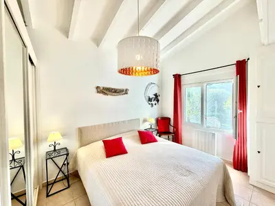 a bedroom with a white bed with red pillows at Villa Argentella, Santa Giulia in Porto-Vecchio