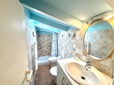 a bathroom with a sink and a toilet and a mirror at Villa Argentella, Santa Giulia in Porto-Vecchio