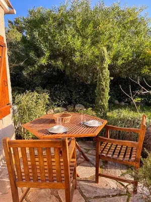 a wooden table and two chairs sitting next to a table at Villa Argentella, Santa Giulia in Porto-Vecchio