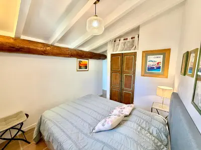a bedroom with a blue bed in a room at Villa Argentella, Santa Giulia in Porto-Vecchio