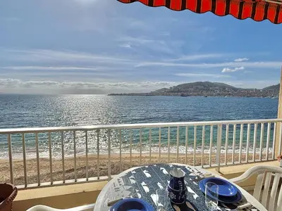 a table on a balcony with a view of the ocean at Studio Corse Azur pieds dans l'eau Ajaccio in Ajaccio