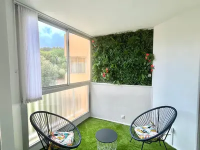 a room with two chairs and a large window at Studio l'orée du bois AJACCIO in Ajaccio