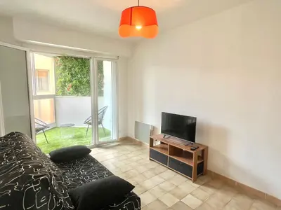 a living room with a couch and a television at Studio l'orée du bois AJACCIO in Ajaccio