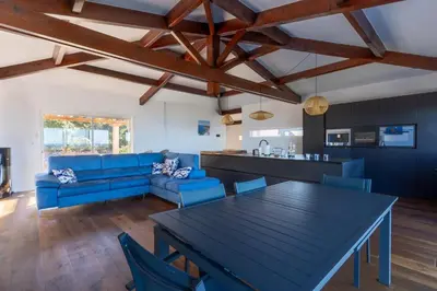 a kitchen and living room with a table and blue chairs at L'Orangeraie de Portigliolo - Vue mer 4 chambres in Coti-Chiavari