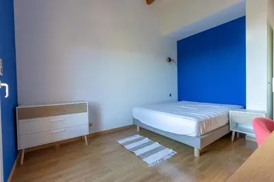 a bedroom with a bed and a blue wall at L'Orangeraie de Portigliolo - Vue mer 4 chambres in Coti-Chiavari