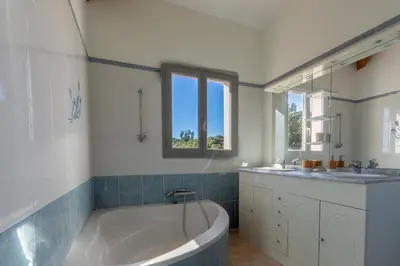 a bathroom with a large tub and a sink and a tub at L'Orangeraie de Portigliolo - Vue mer 4 chambres in Coti-Chiavari