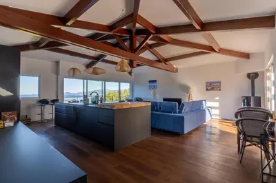a kitchen and living room with wooden ceilings at L'Orangeraie de Portigliolo - Vue mer 4 chambres in Coti-Chiavari