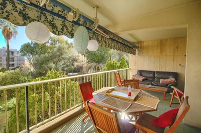 a balcony with a table and chairs and a couch at Appartement Le Kent centre ville AJACCIO in Ajaccio