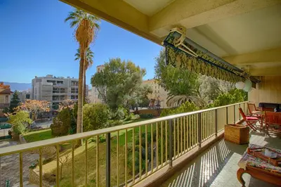 a balcony with a view of a palm tree at Appartement Le Kent centre ville AJACCIO in Ajaccio