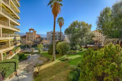 a view of a park with palm trees and buildings at Appartement Le Kent centre ville AJACCIO in Ajaccio