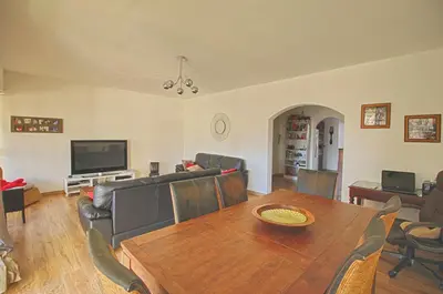 a living room with a wooden table and a television at Appartement Le Kent centre ville AJACCIO in Ajaccio