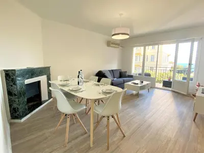 a living room with a table and chairs and a fireplace at Appartement Sacré Coeur 6 couchages AJACCIO in Ajaccio